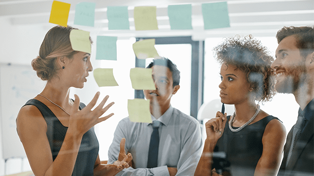 Group of people discussing in front of post it notes